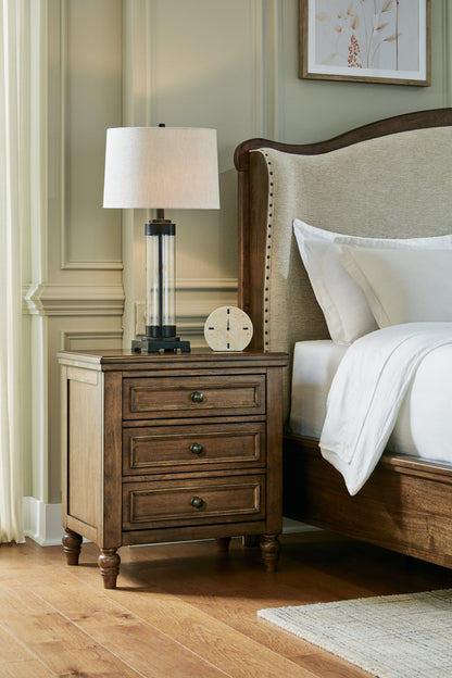 Sturlayne Queen Upholstered Panel Bed with Mirrored Dresser, Chest and 2 Nightstands in Brown from Ashley - Luna Furniture